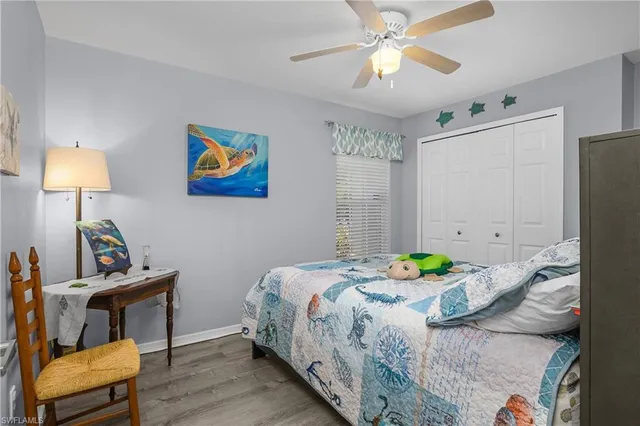 a bedroom that has a bed and a lamp on the dresser