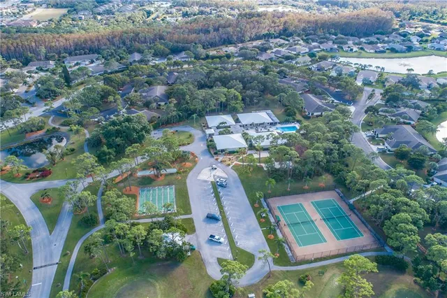 an aerial view of residential houses with outdoor space and trees