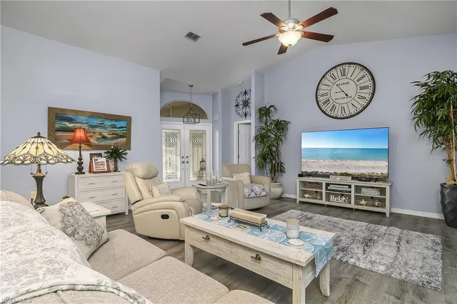 a living room with furniture a clock and a window