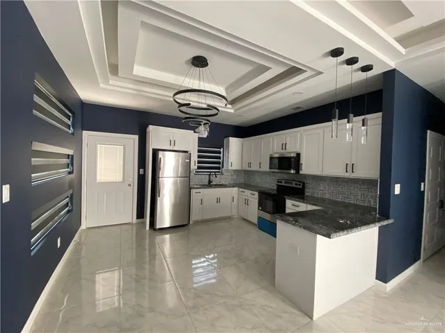 a kitchen with stainless steel appliances granite countertop a sink a stove and a refrigerator