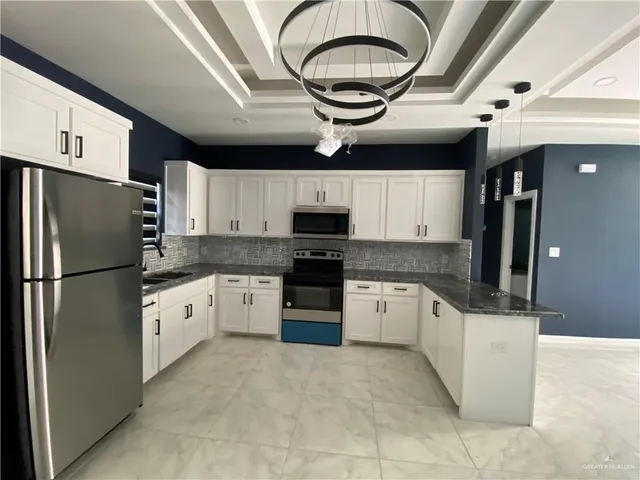 a kitchen with stainless steel appliances granite countertop a refrigerator and a stove top oven