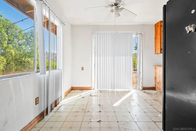 a view of a room with floor to ceiling windows and potted plants