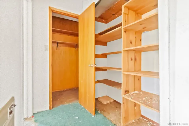 a view of an empty room with closet and wooden floor