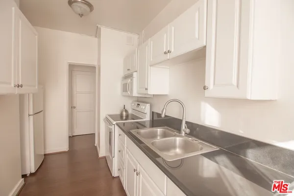 a kitchen with granite countertop a sink and cabinets