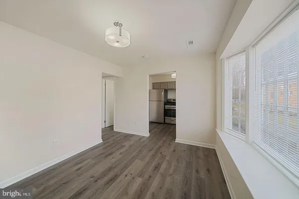 a view of empty room with wooden floor and window