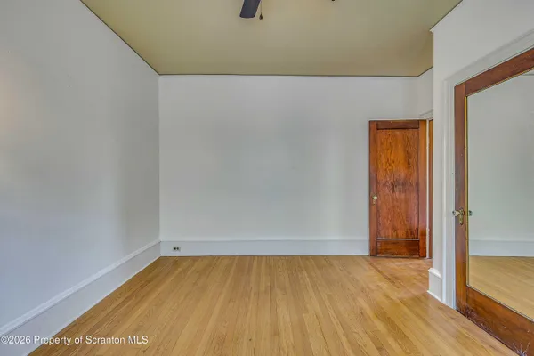 a view of a room that has a window and wooden floor