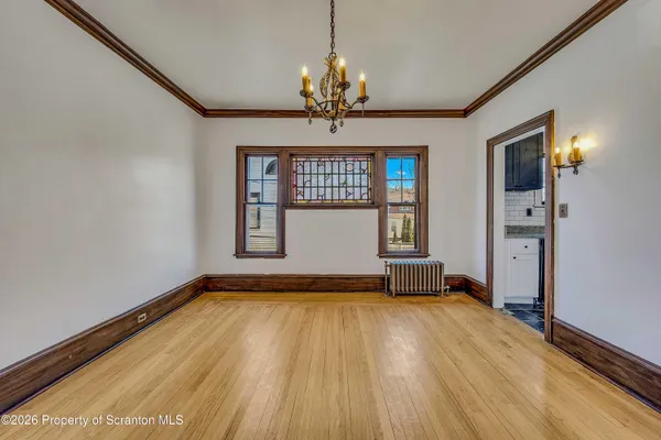 a view of a room with wooden floor chandelier and a window