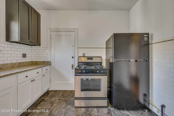 a kitchen with granite countertop a sink stove and cabinets
