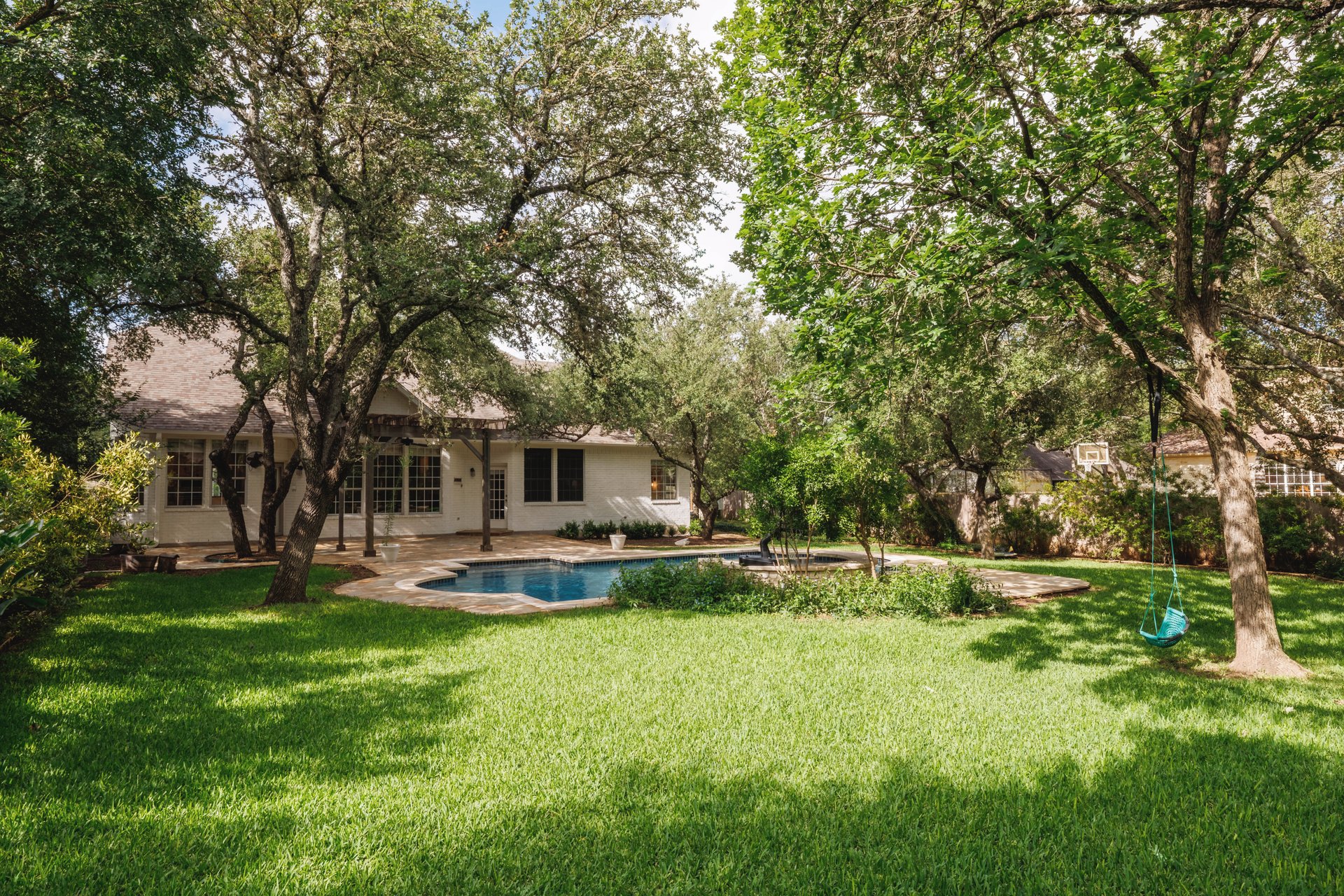5512 Ballenton Lane Austin, TX 78739 - Photo 39 of 40 A private backyard oasis awaits with a refreshing pool surrounded by lush landscaping and mature trees.