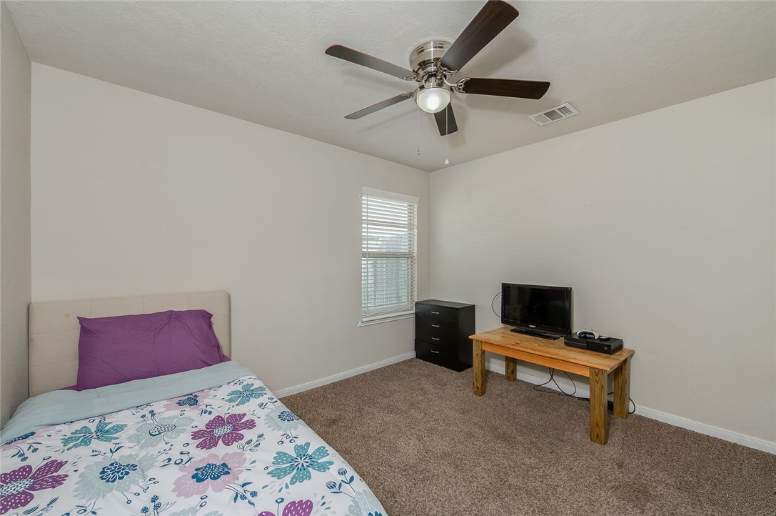 2702 Redcap Street Bryan, TX 77803 - Photo 12 of 17 a bedroom with a bed and a chandelier