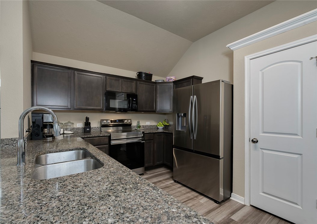 2702 Redcap Street Bryan, TX 77803 - Photo 3 of 17 a kitchen with stainless steel appliances granite countertop a refrigerator stove and sink