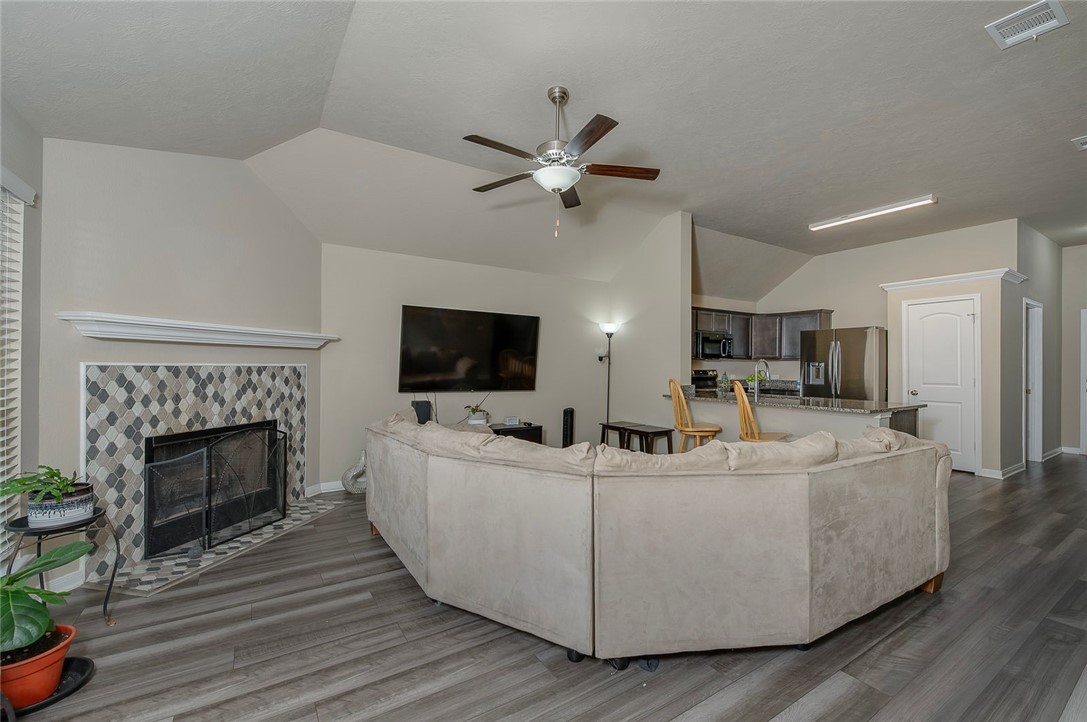 2702 Redcap Street Bryan, TX 77803 - Photo 6 of 17 a living room with furniture a fireplace and a flat screen tv