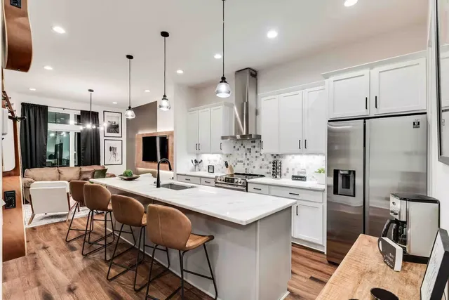 a kitchen with stainless steel appliances kitchen island a refrigerator and a stove top oven