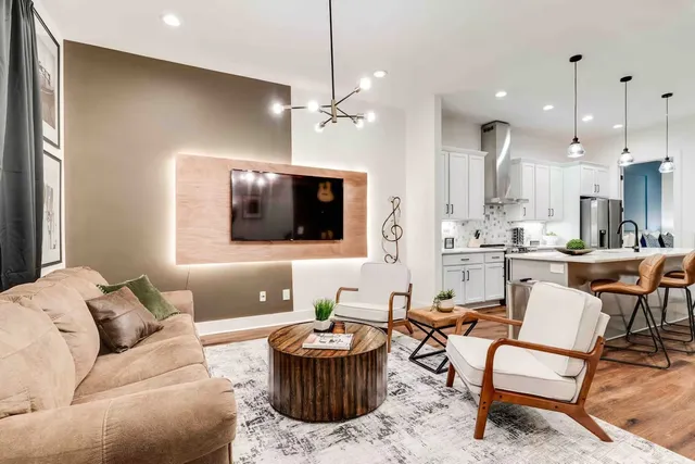 a living room with furniture kitchen and a chandelier