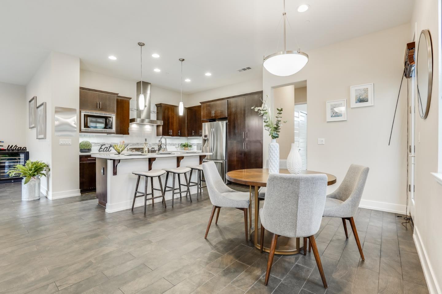 465 Landeros Drive San Mateo, CA 94403 - Photo 2 of 36 a kitchen with stainless steel appliances kitchen island granite countertop a refrigerator a stove a microwave oven a dining table and chairs with wooden floor