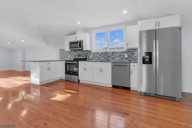 a kitchen with stainless steel appliances granite countertop a refrigerator and a stove top oven