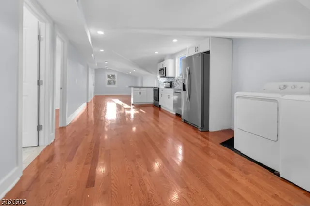 a view of a kitchen with refrigerator and wooden floor