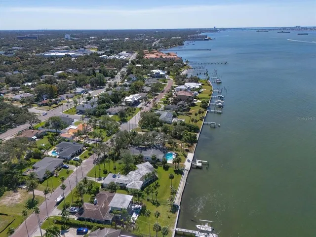 an aerial view of ocean and residential houses with outdoor space