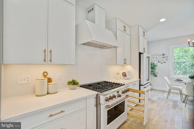 a kitchen with stainless steel appliances a stove a white cabinets and a refrigerator