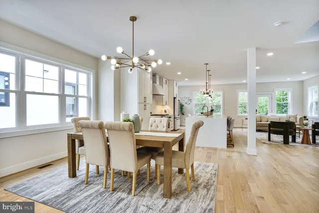 a dining room with furniture a chandelier and wooden floor