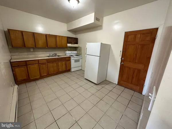 a kitchen with a refrigerator sink and cabinets