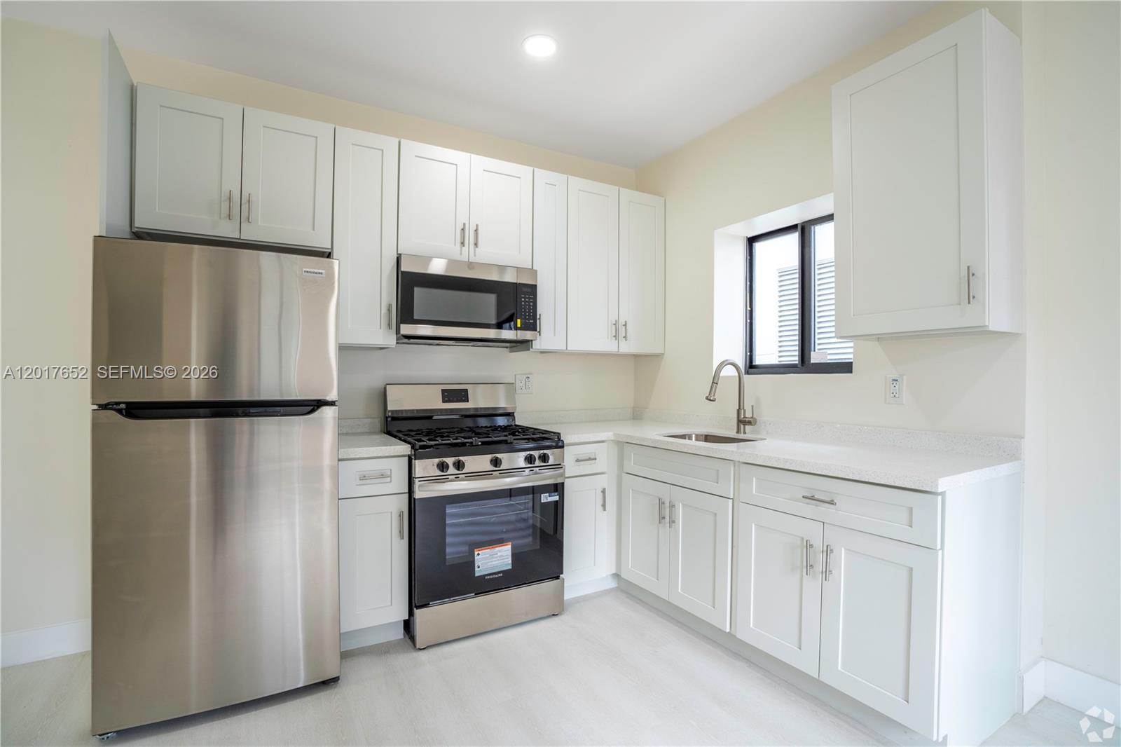 433 Southwest 6th Street, Unit 15 Miami, FL 33130 - Photo 8 of 12 a kitchen with white cabinets and stainless steel appliances