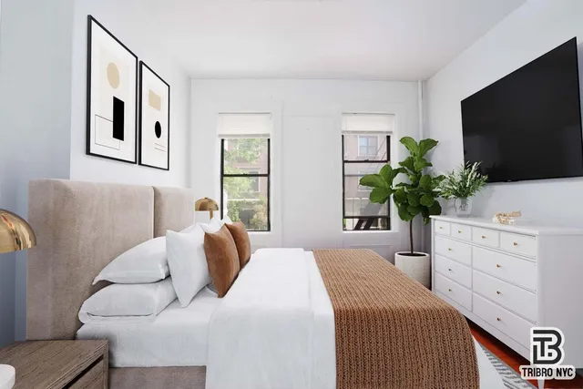 a bedroom with a large bed and a flat screen tv