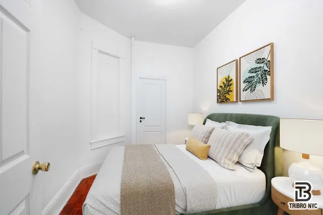 a bedroom with a bed and a painting on the wall