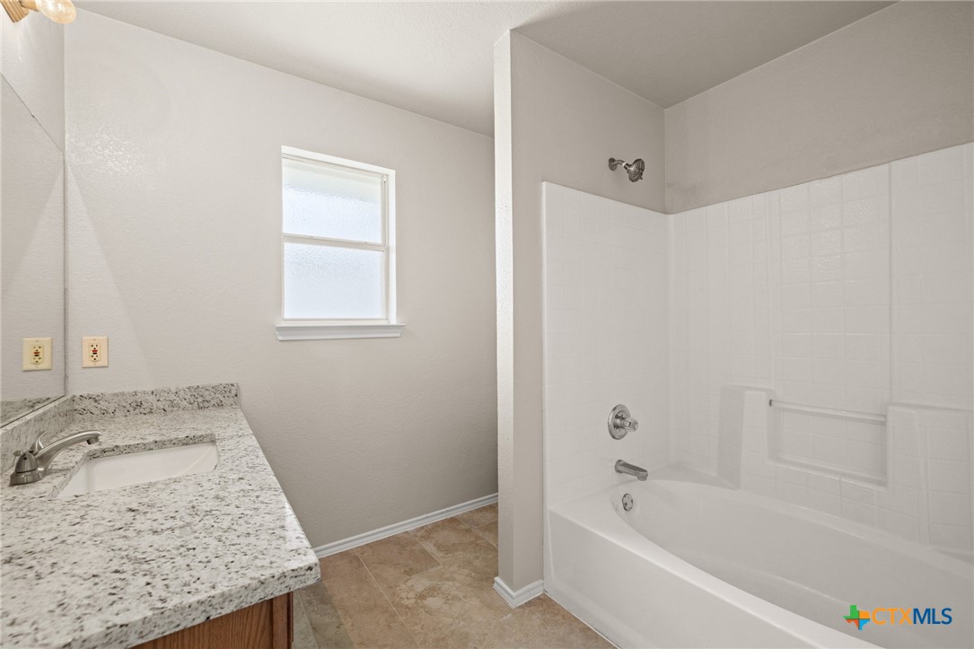 214 Timber Ridge Drive Nolanville, TX 76559 - Photo 16 of 31 a bathroom with a granite countertop tub sink and mirror