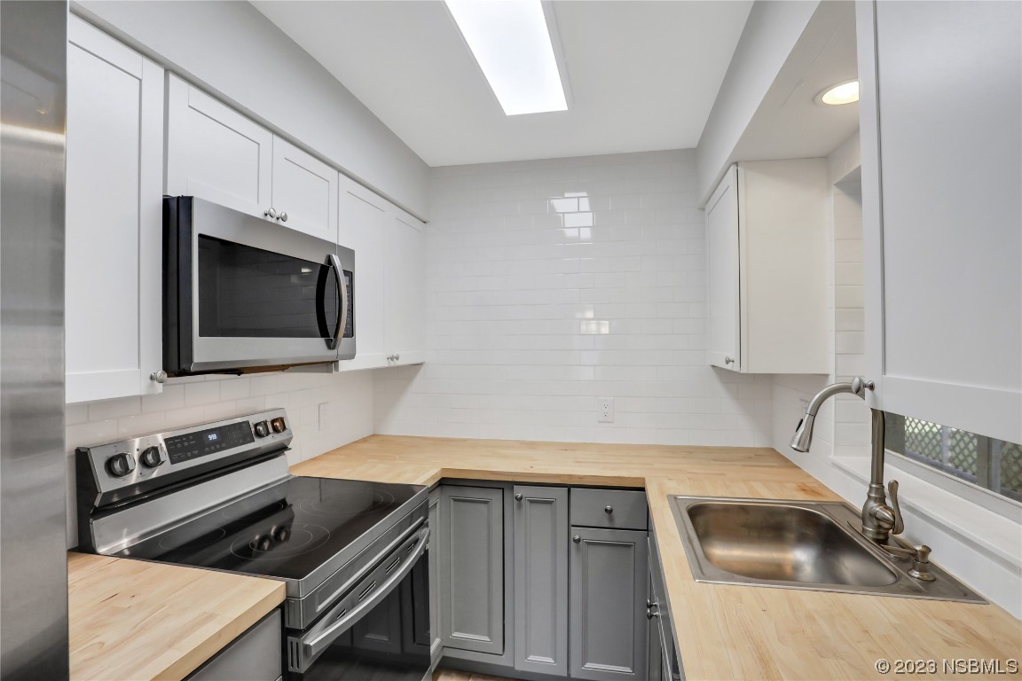 436 Palmetto Street Edgewater, FL 32132 - Photo 11 of 36 a kitchen with a sink and a stove top oven