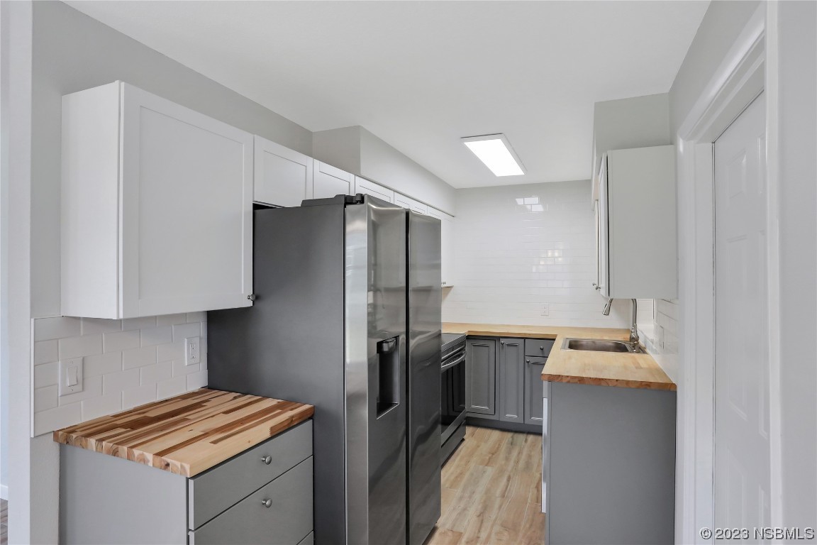 436 Palmetto Street Edgewater, FL 32132 - Photo 10 of 36 a kitchen with a refrigerator and a sink