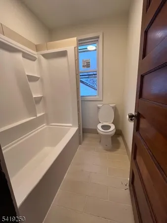 a bathroom with a bathtub and a toilet