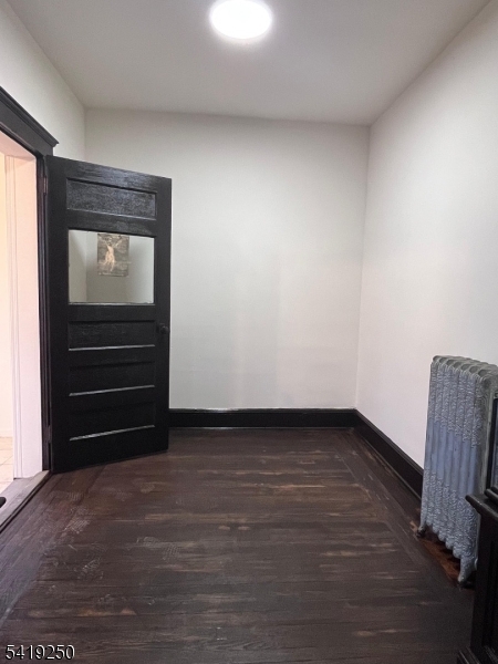 154 Spring Street Orange, NJ 07050 - Photo 8 of 8 a view of an empty room with wooden floor and a window