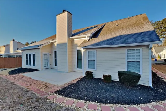 a view of a house with backyard and a tree