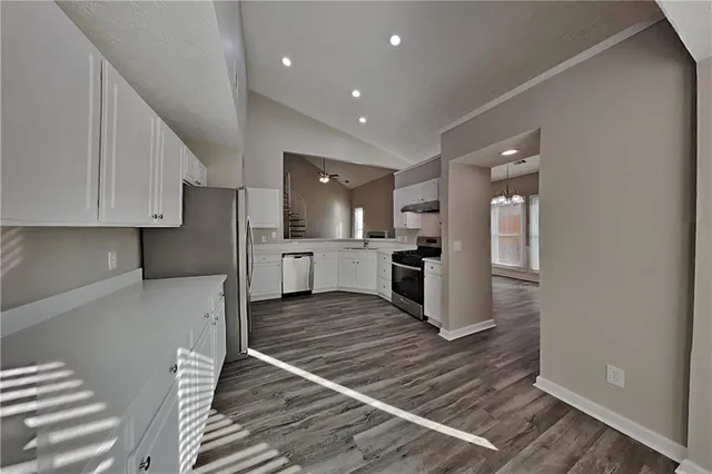 a kitchen with stainless steel appliances granite countertop a refrigerator and a stove top oven