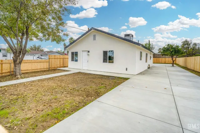 a view of an house with backyard and trees