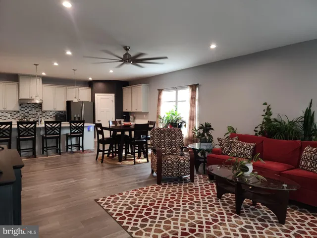 a living room with furniture a dining table and a potted plant