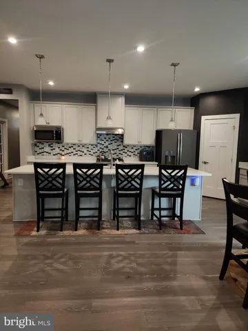 a kitchen with stainless steel appliances a refrigerator a sink a stove a microwave and wooden cabinets