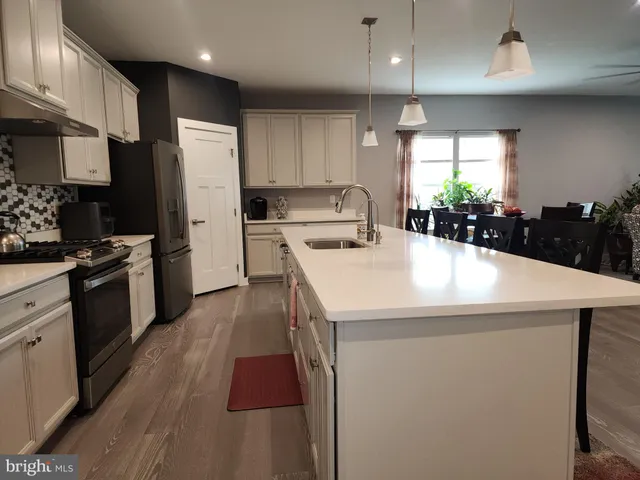 a kitchen with stainless steel appliances granite countertop a refrigerator and a stove