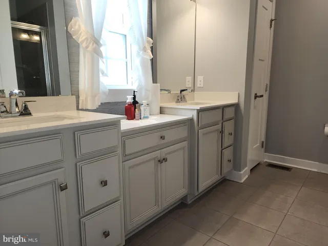 a hallway with white cabinets and black appliances