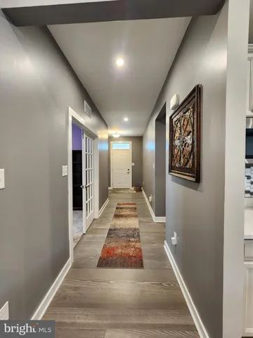 a view of a hallway with wooden floor and entryway