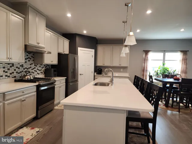 a kitchen with kitchen island a stove a sink and a refrigerator