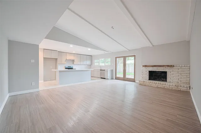 a view of empty room with wooden floor and fireplace