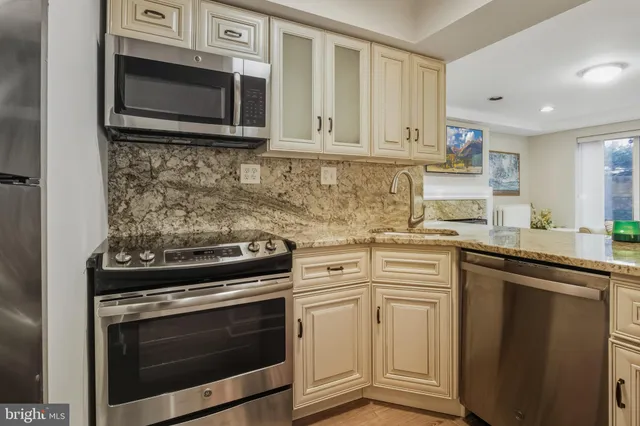 a kitchen with stainless steel appliances granite countertop a sink stove and cabinets