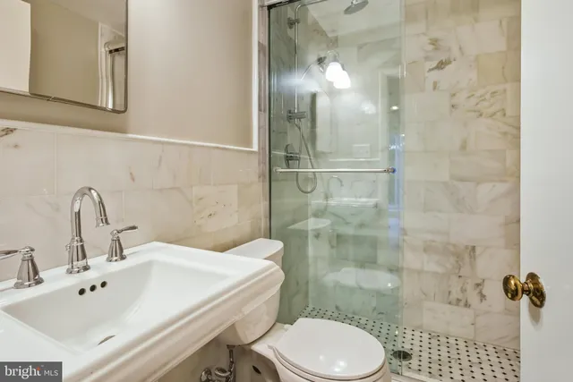 a view of a bathroom from a hallway with wooden floor