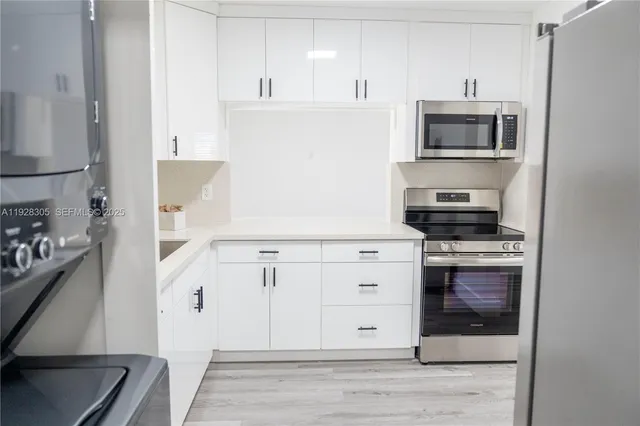 a kitchen with stainless steel appliances a stove microwave and cabinets
