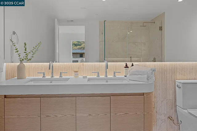 a bathroom with a granite countertop sink mirror and toilet