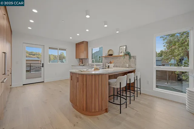 a kitchen with a sink and white cabinets with wooden floor