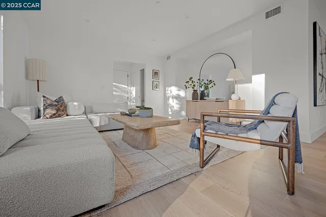 a living room with furniture a table and white walls