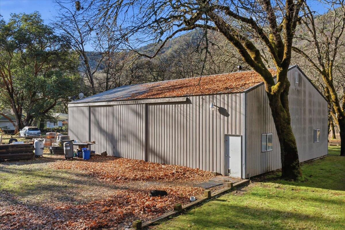 1401 Upper River Road Gold Hill, OR 97525 - Photo 3 of 8 a backyard of a house with wooden fence and large trees